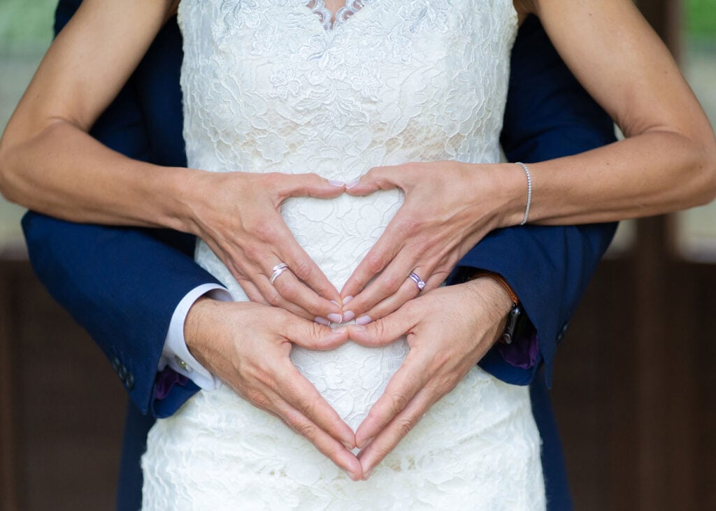 Lloyd Dunkley Photography, Bride and groom both making a love heart shapes with their hands