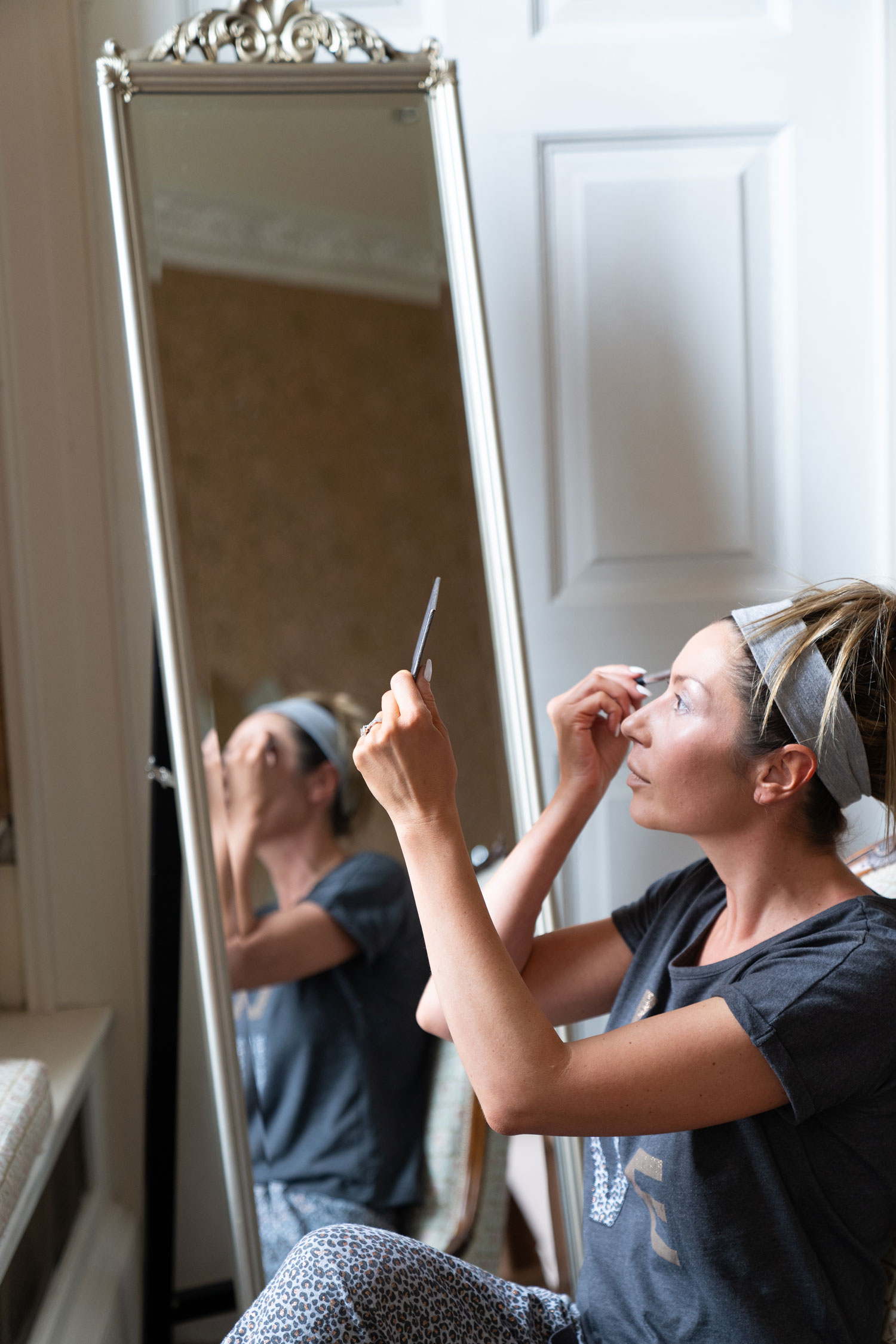Lloyd Dunkley Photography, Bride prepares for her wedding at Colwick, Nottingham, by putting on finishing touches to her makeup and attire.